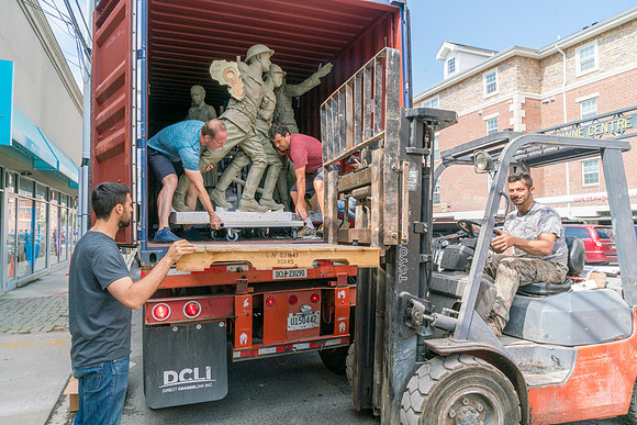Sculptures being unloaded with a dolly