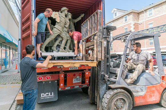 Sculptures being unloaded with a dolly