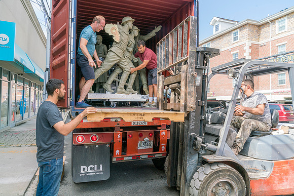 Sculptures being unloaded with a dolly
