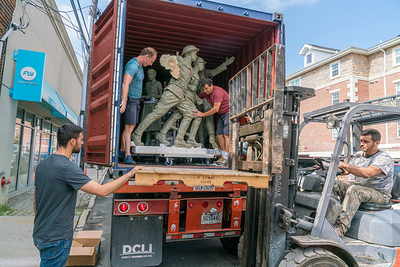 Sculptures being unloaded with a dolly